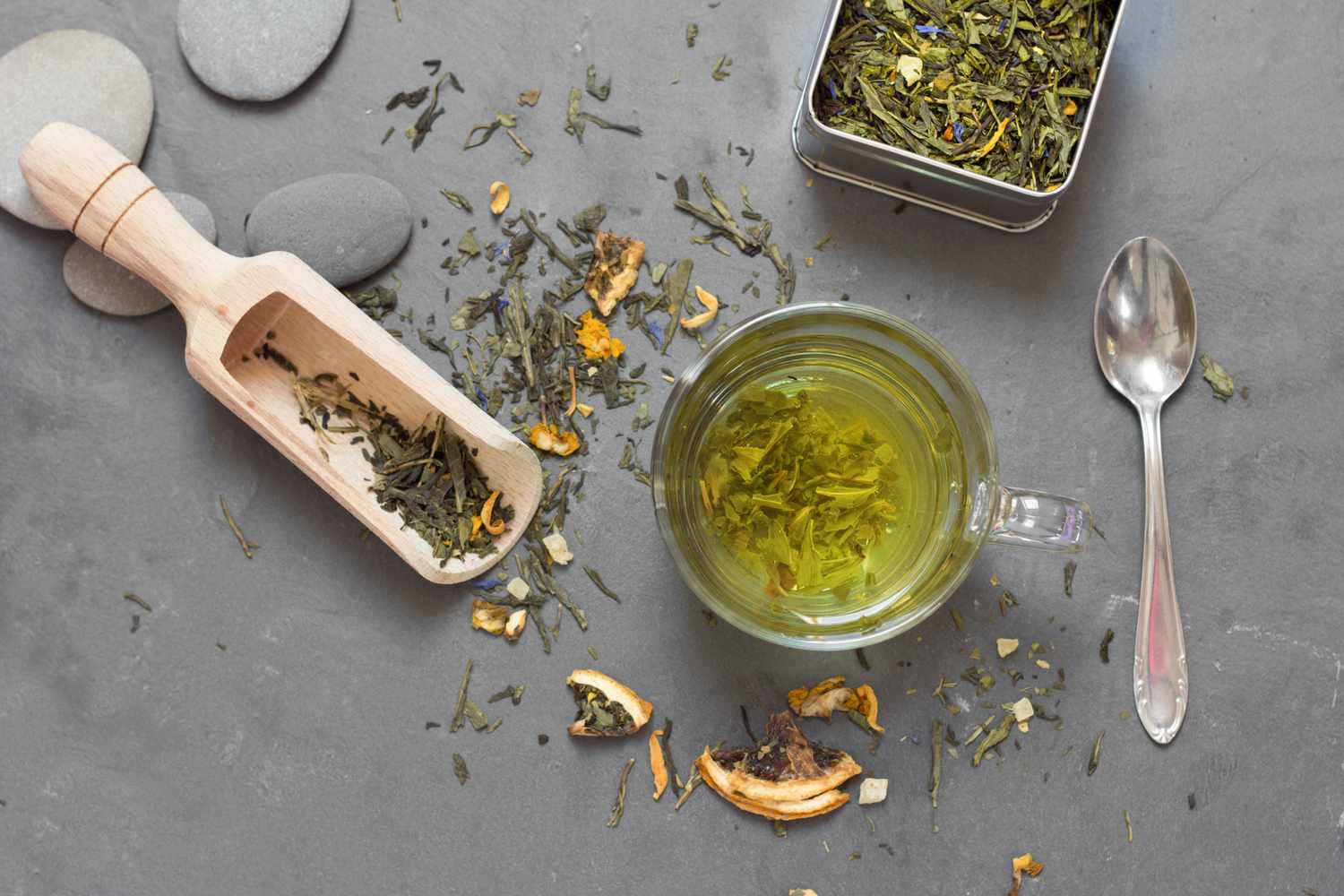 Green tea leaves on a table and steeping in cup