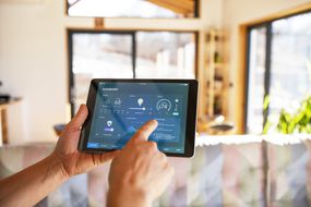 Person using tablet with smart home control functions at home