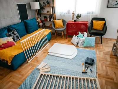 Unassembled flat pack furniture parts scattered in living room