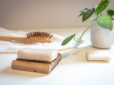 shampoo bar, wooden hair brush, and pothos plant for green beauty care