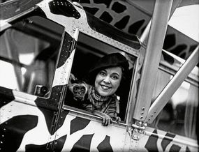 Osa Johnson sits in an airplane with a monkey