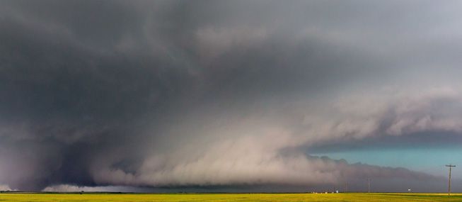 A wall cloud with a cauda cloud tail forms over Elmer, Oklahoma.