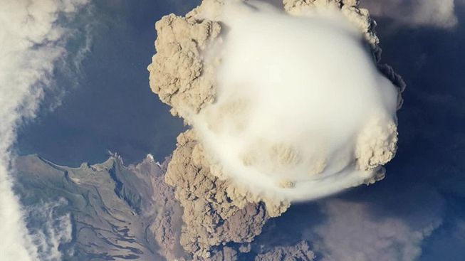 A pileus cloud appears over a volcanic cloud produced by Sarychev Peak
