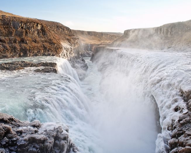 Clouds form near a waterfall in Iceland