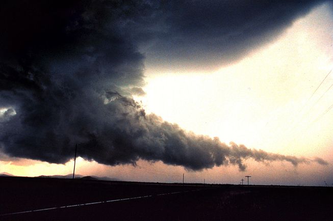 A wall cloud with a tail extending from the base