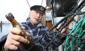 Fisherman pulling an old bottle from fishing net