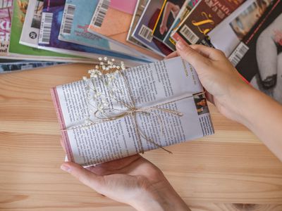 a book is wrapped with upcycled magazines instead of new wrapping paper