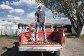 man stands in back of truck
