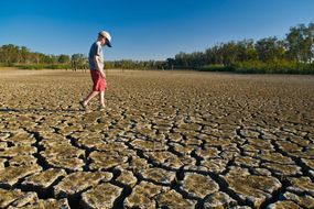 boy walking on cracked dry earth