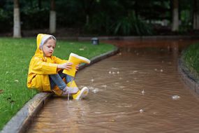 A child empties her rain boot