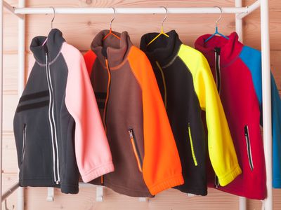 Colorful fleece jackets are hanging on hangers