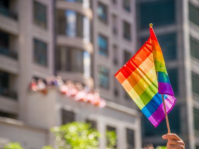 Cropped Hand Holding Rainbow Flag In City
