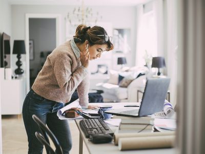Woman standing by a table working from home