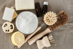 glass bowl of baking soda and eco friendly brushes and cleaning products for kitchen