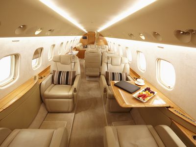 interior of an expensive private plane with leather seats and a fruit tray