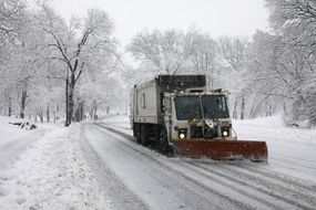 Snowplow truck clearing a snow-covered street
