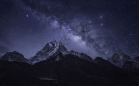 A wildly starry night sky over mountains