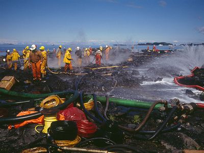 Teams of firefighters cleaning the Alaskan coast following the Exxon Valdez oil spill. 