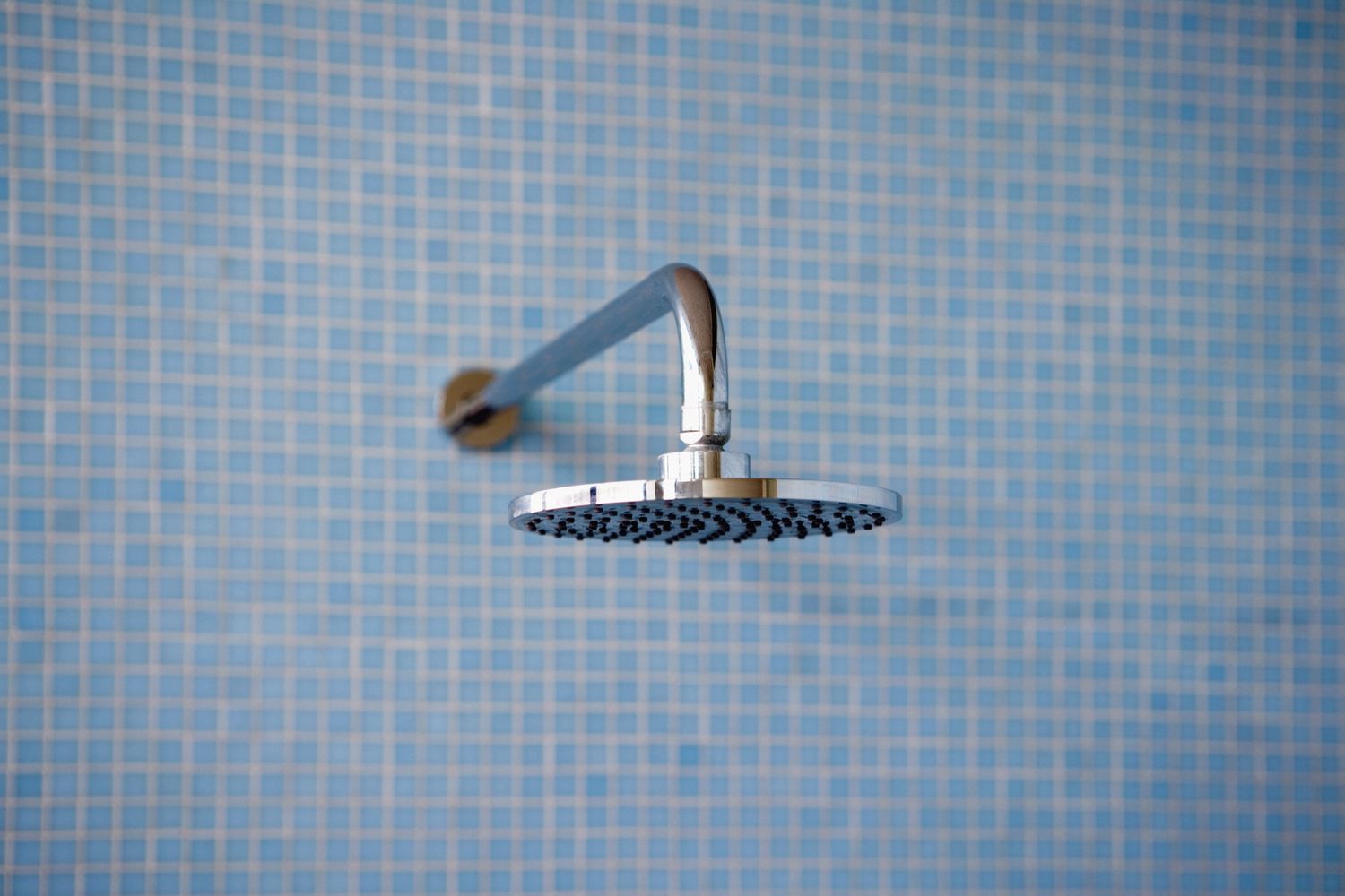 minimalist blue tiled shower with modern flat shiny chrome shower head
