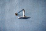 minimalist blue tiled shower with modern flat shiny chrome shower head