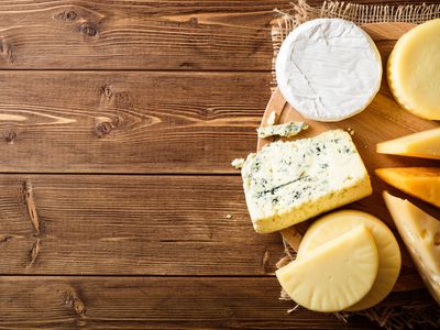 Assortment of cheeses against a wood board