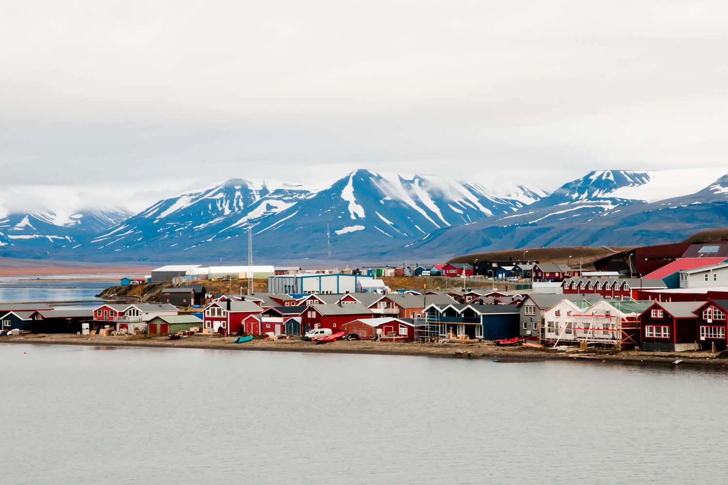 Colorful village and snowcapped mountains by the sea