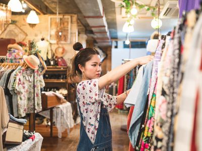 young hip woman shops for clothing in bright vintage store with fun lights