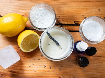 flat lay of ingredients needed to DIY deodorant, including coconut oil, lemon, oils, and crystal