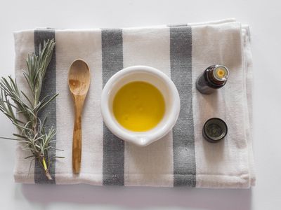 a striped towel with carrier oil and essential oil for diy hair moisturizer recipes