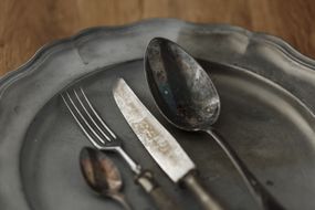 Old metal scalloped tray with eating utensils