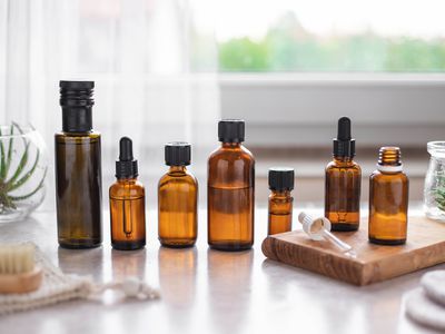 an array of amber-colored bottles filled with oil for a beauty cleansing method