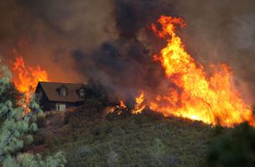 Flames from the Rocky Fire approach a house on July 31, 2015 in Lower Lake, California. 